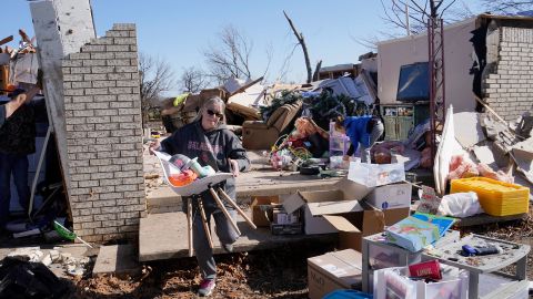 Belinda Penner carries belongings from her cousin's home that was destroyed by a tornado on Tuesday, December 13, 2022, in Wayne, Oklahoma.