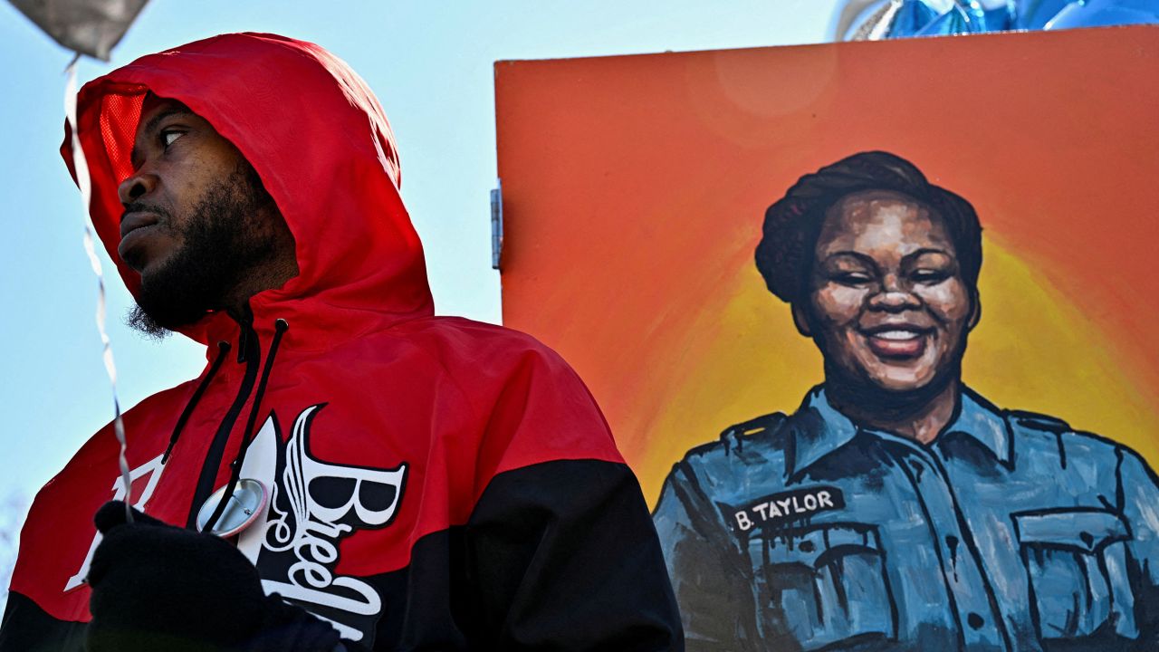 Kenneth Walker III stands next to a painting of Breonna Taylor at a gathering in March, on the second anniversary of her death.