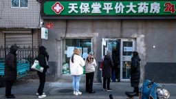 Customers queue at a pharmacy in Beijing, China, on Tuesday, December 13. 2022.