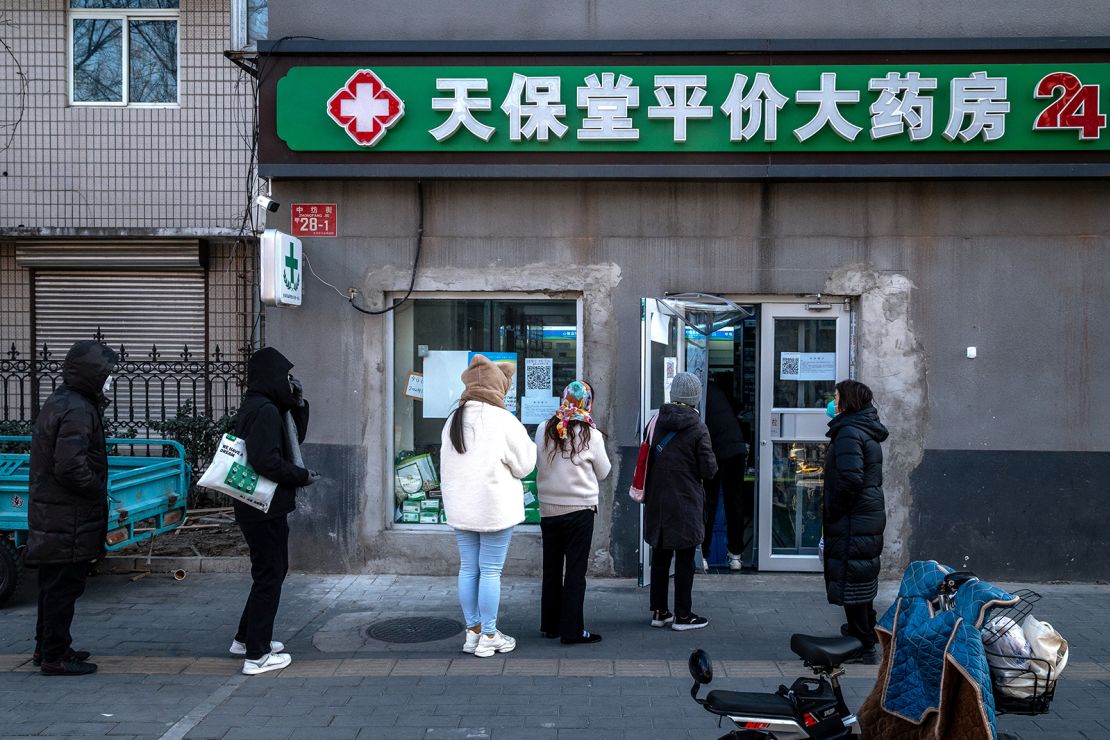 Customers queue at a pharmacy in Beijing, China, on Tuesday, December 13. 2022.