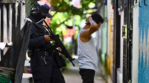 A police officer questions a young man during a security operation against gang violence in Soyapango, just east of the capital San Salvador, on August 16, 2022.