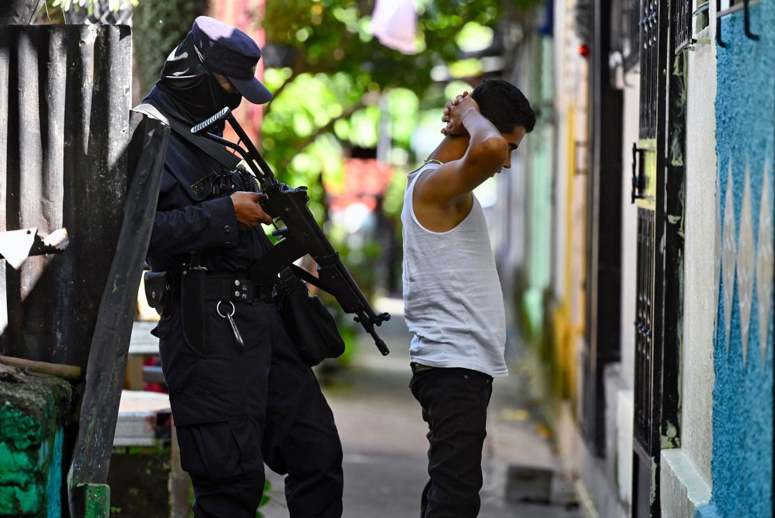 A police officer questions a young man during a security operation against gang violence in Soyapango, just east of the capital San Salvador, on August 16, 2022.
