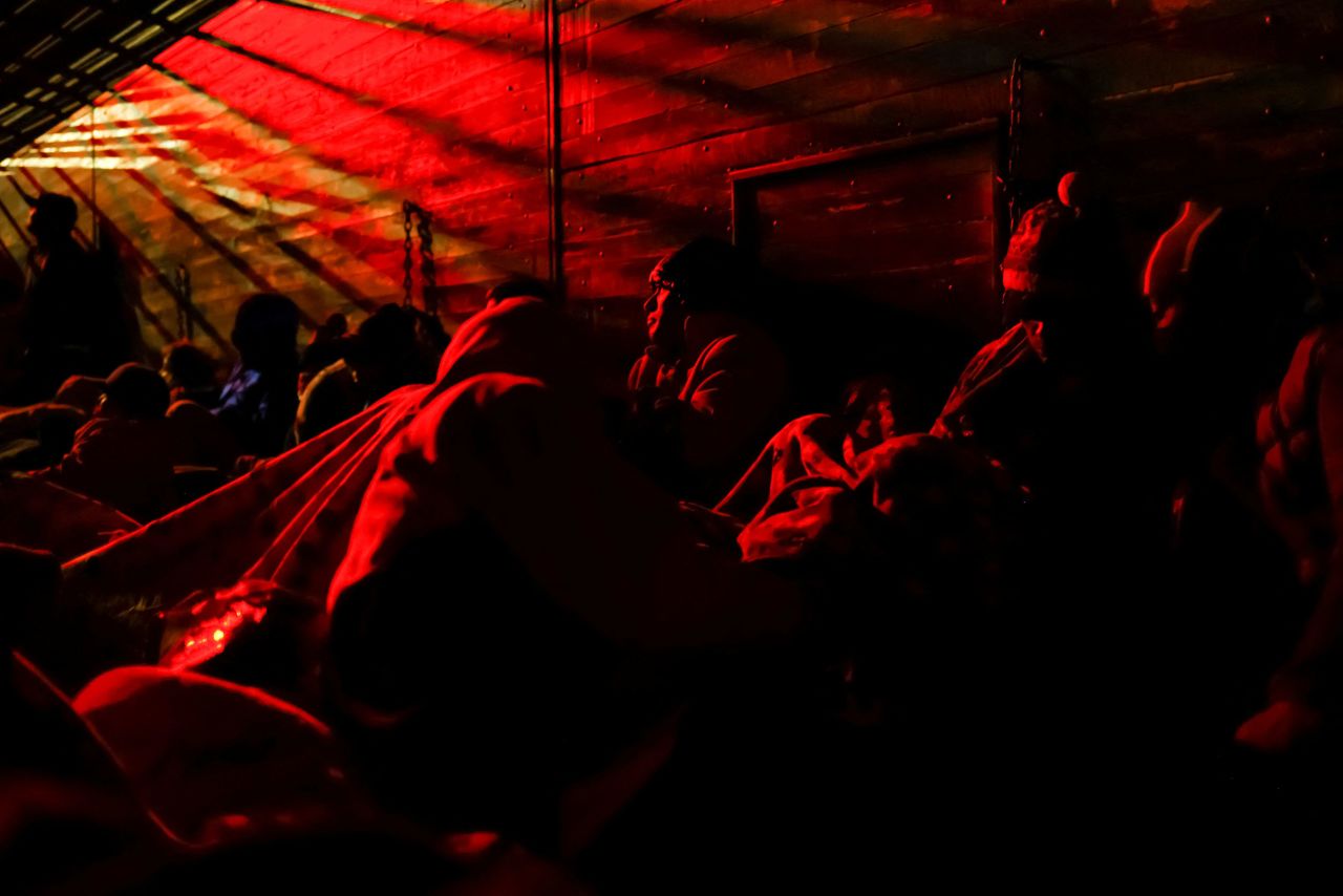 Migrants ride aboard a box trailer as they travel to the US border on December 10.