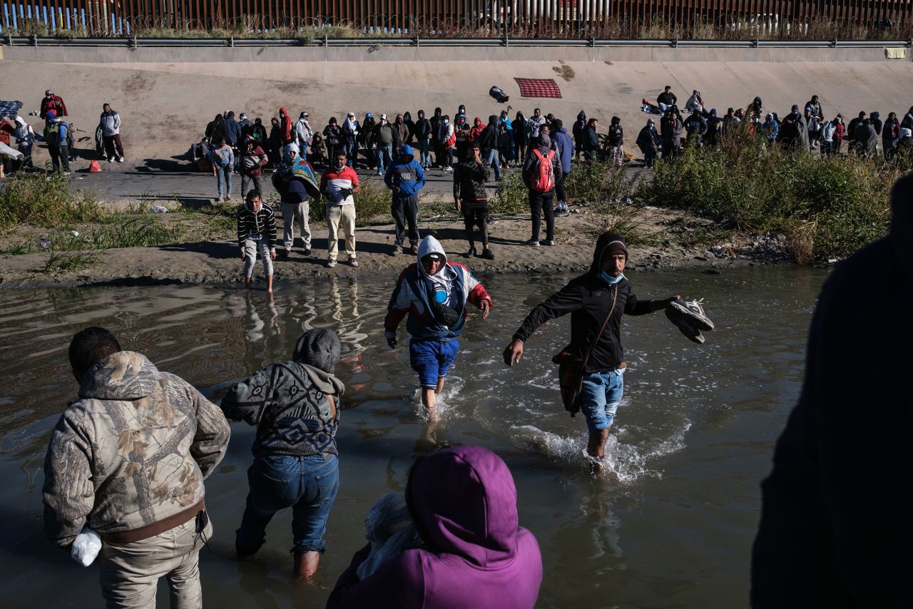 Migrants, mostly from Nicaragua, are seen from Ciudad Juarez, along the shore of the Rio Grande and below the US border wall on December 13.