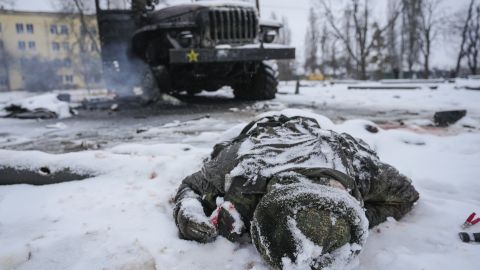 2022年2月25日星期五，在乌克兰哈尔科夫郊区一辆被摧毁的俄罗斯军用多管火箭发射器车旁边，一名军人的尸体被雪覆盖。