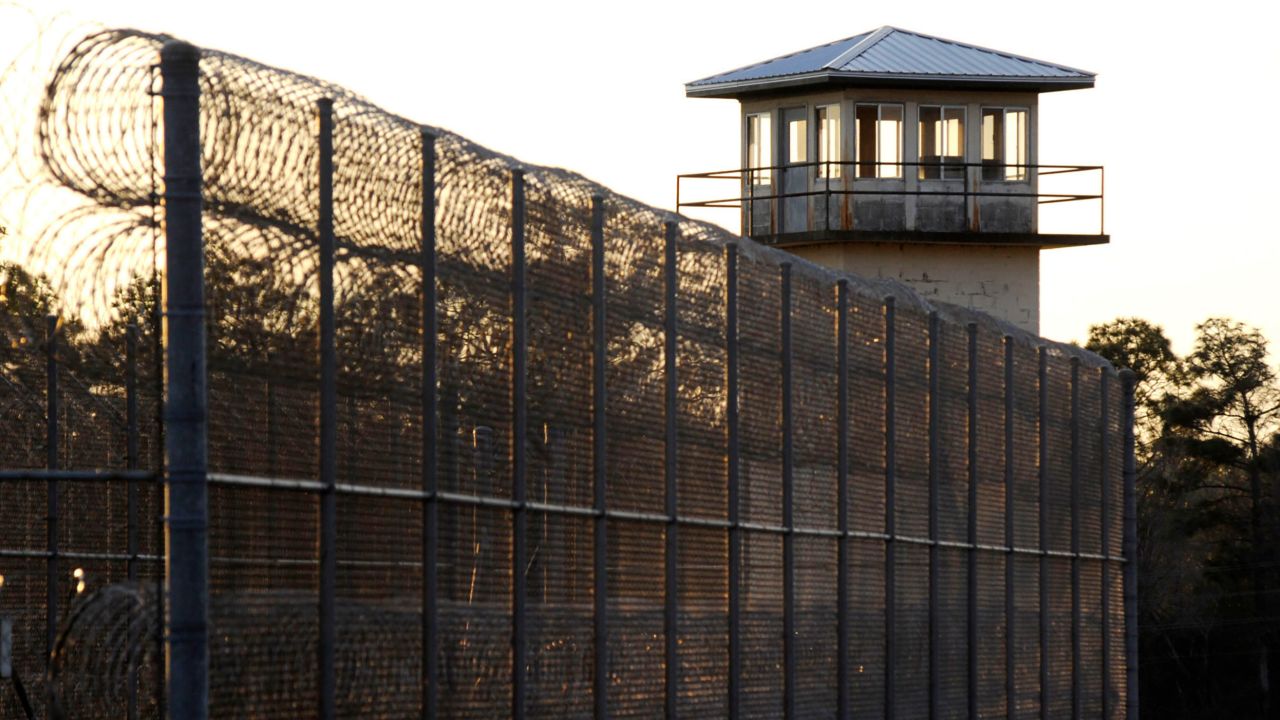 The sun sets in January behind Holman Prison, home to Alabama's death row.