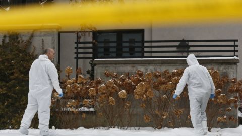 法医学捜査官は、2017 年 12 月に遺体が発見されたバリーとハニー シャーマンの家の外で証拠を収集します。  