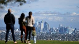People enjoy the sunny afternoon on New Year's Eve in a Los Angeles park with a view of the downtown skyline, December 31, 2021. 