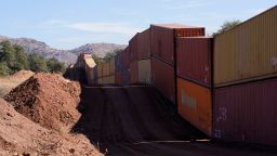 A long row of double-stacked shipping contrainers provide a new wall between the United States and Mexico in the remote section area of San Rafael Valley, Ariz., Thursday, Dec. 8, 2022. Work crews are steadily erecting hundreds of double-stacked shipping containers along the rugged east end of Arizona's boundary with Mexico as Republican Gov. Doug Ducey makes a bold show of border enforcement even as he prepares to step aside next month for Democratic Governor-elect Katie Hobbs.  (AP Photo/Ross D. Franklin)