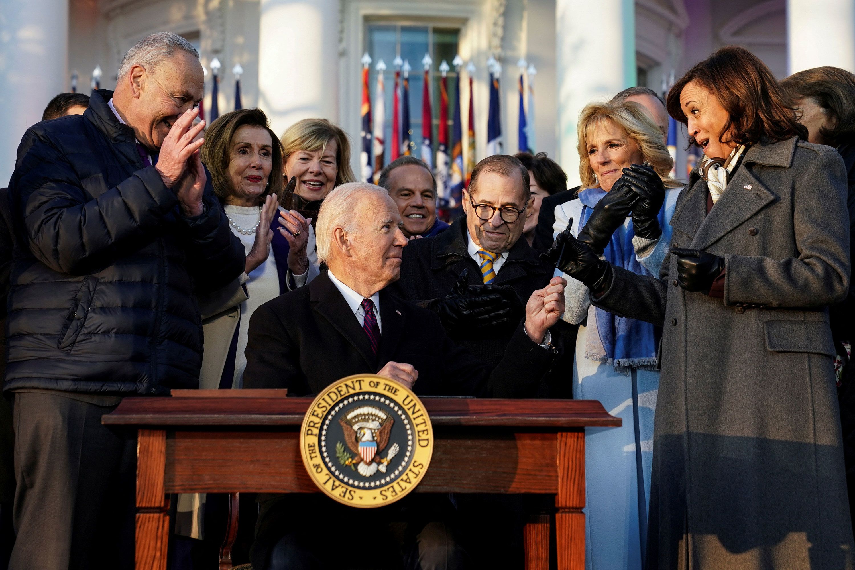 US President Joe Biden hands a pen to Vice President Kamala Harris on Tuesday, December 13, after signing new federal protections for same-sex and interracial couples.