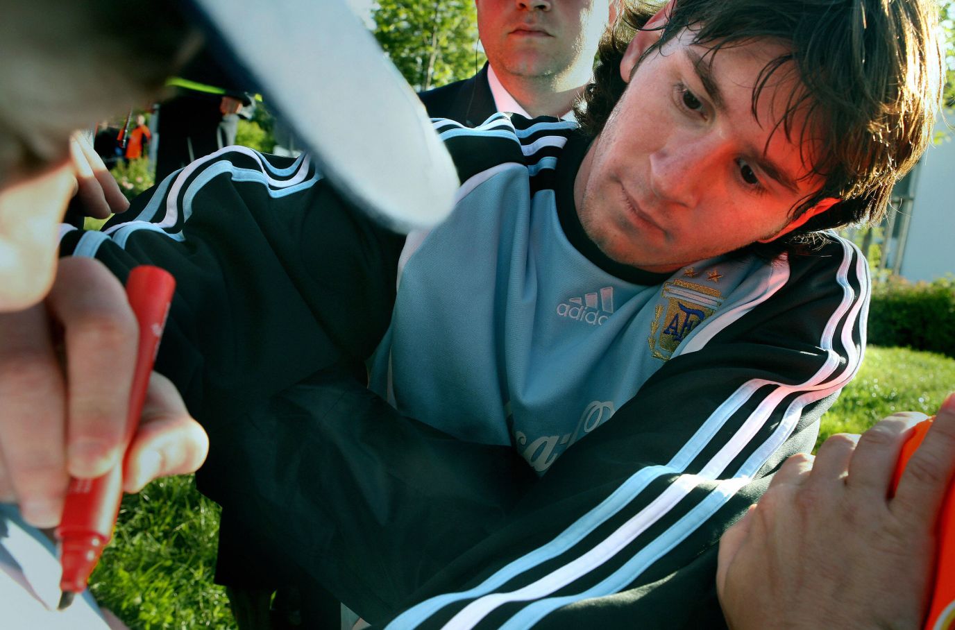 Messi signs autographs while training ahead of the World Cup in Gerмany in June 2006.