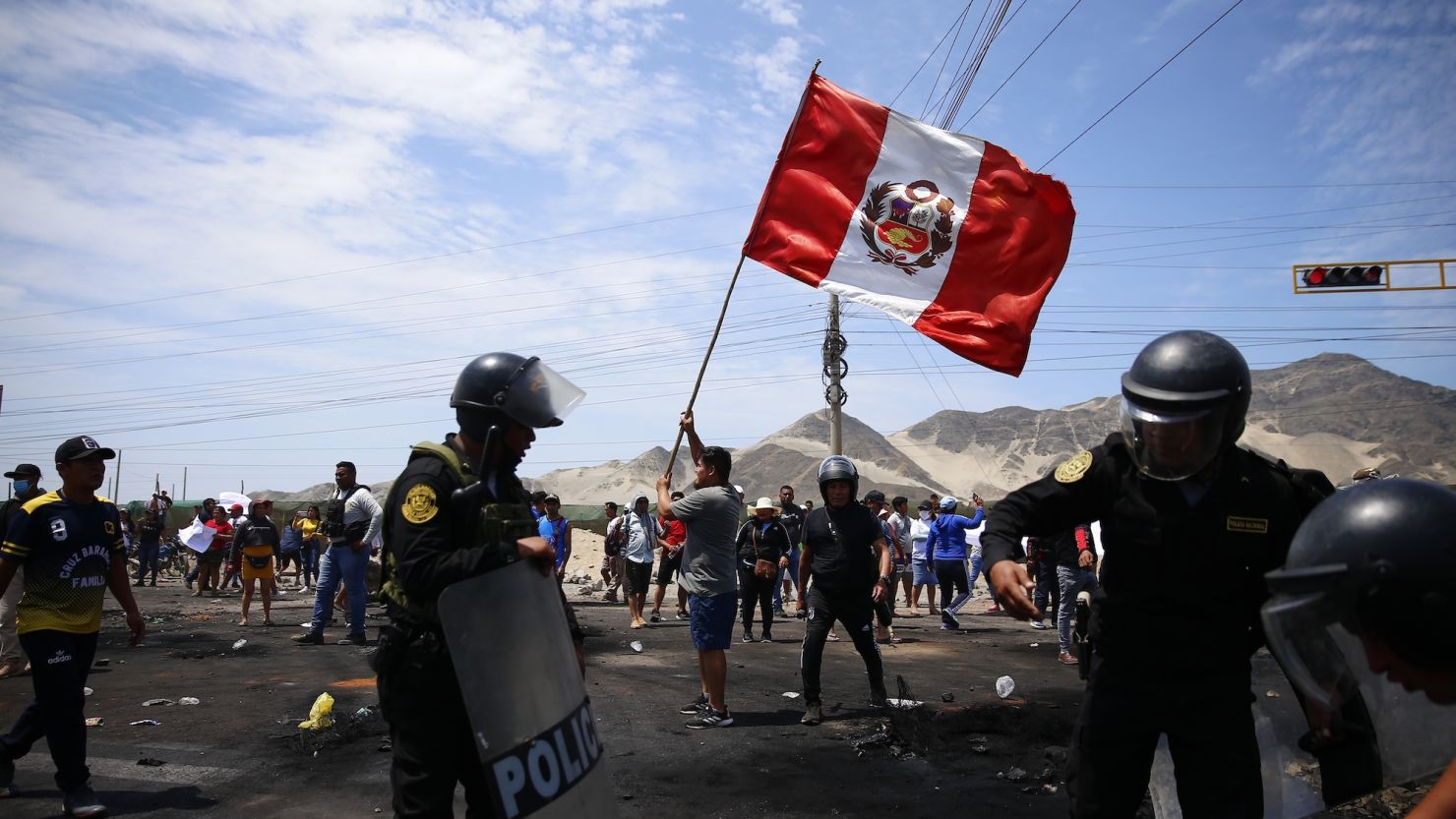 Supporters of ousted Peruvian President Pedro Castillo protest on the Pan-American North Highway while police officers arrive to clear debris, in Chao, Peru, Thursday, Dec. 15, 2022. 