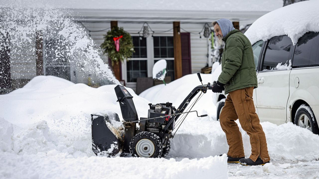 A man clears a driveway with a snowblower on Thursday, Dec. 15, 2022, in Duluth, Minnesota.