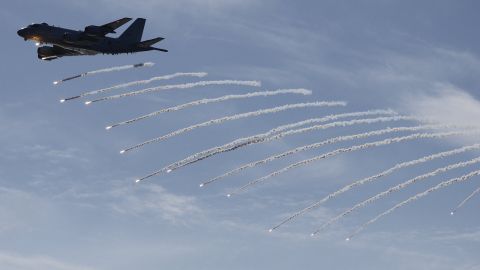 A Japan Maritime Self-Defence Force Kawasaki P-1 patrol aircraft fires flares during an International Fleet Review commemorating the 70th anniversary of the founding of the Japan Maritime Self-Defense Force at Sagami Bay on November 6 off Yokosuka, Japan.