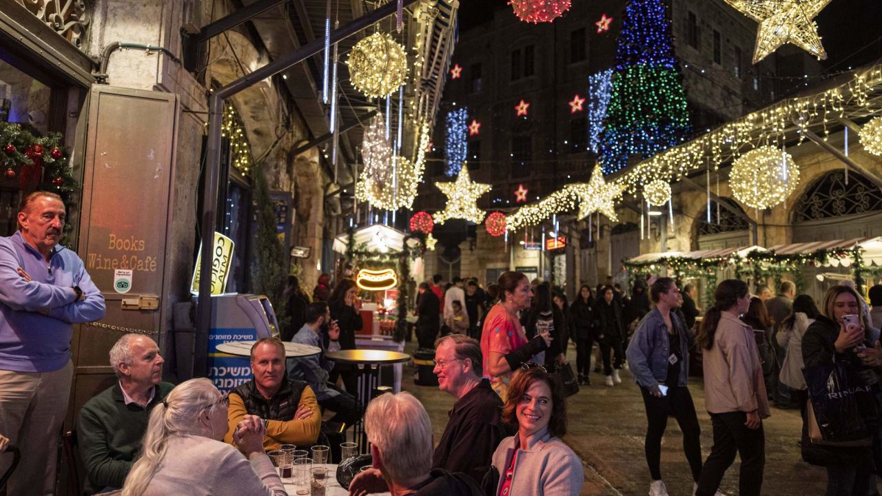 People sit together with drinks outside a venue at a Christmas market in the Christian quarter of Jerusalem's old city on Thursday. 
