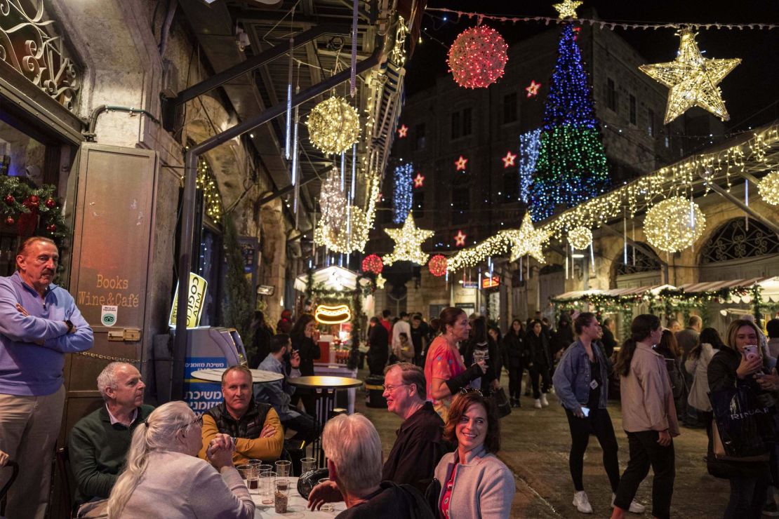 People sit together with drinks outside a venue at a Christmas market in the Christian quarter of Jerusalem's old city on Thursday. 