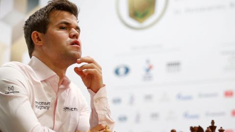 Magnus Carlsen sits in front of a chess board before a game at the 2018 World Rapid and Blitz Chess Championships.