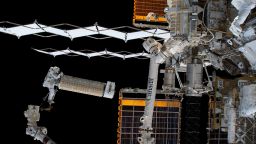 NASA astronaut and Expedition 68 Flight Engineer Josh Cassada holds a roll-out solar array as he rides the Canadarm2 robotic arm toward the Starboard-4 truss segment installation site.