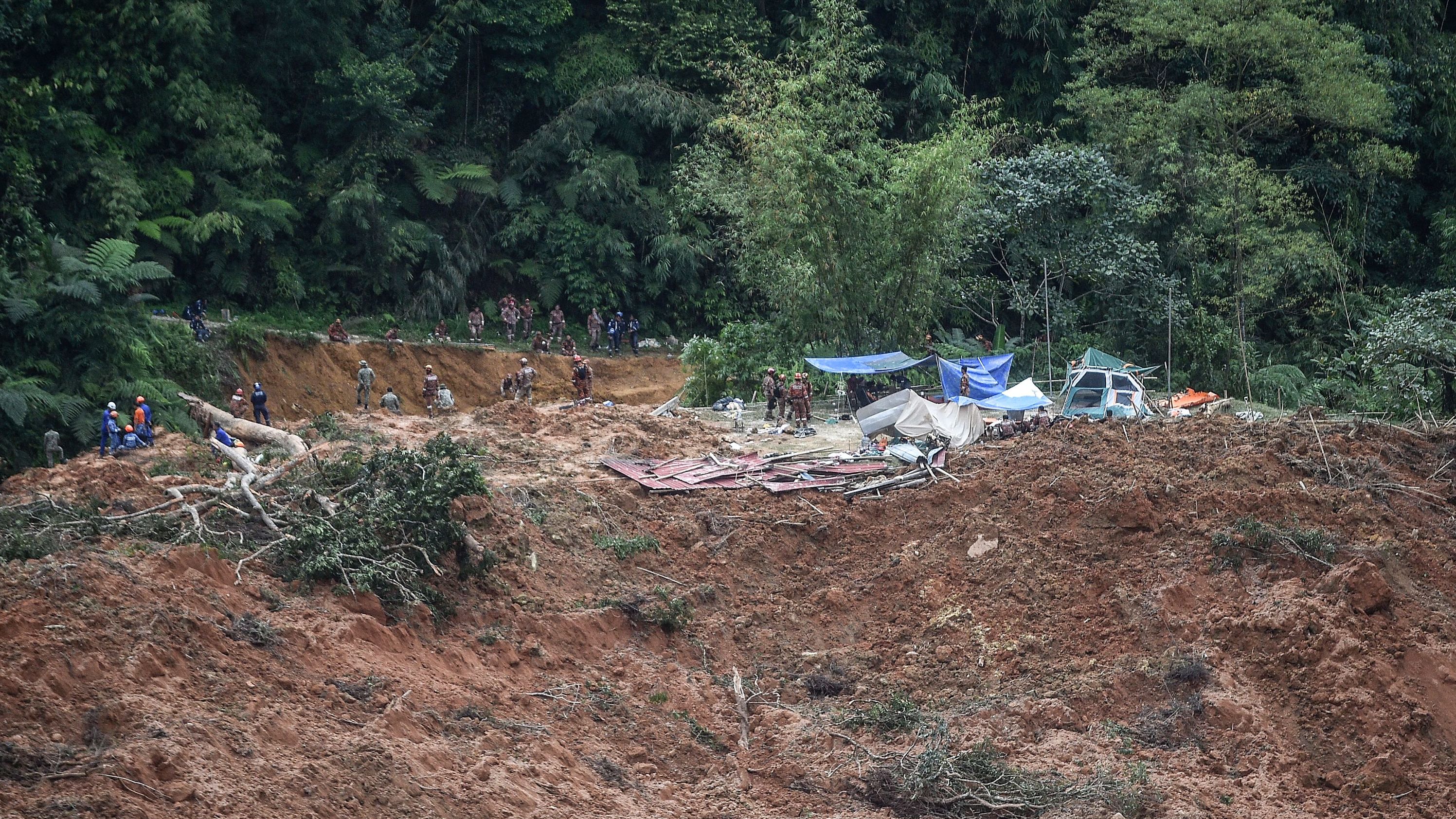 Malaysian officials inspect the site damaged after the landslide.