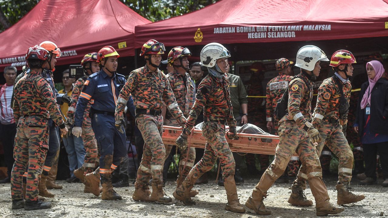 Fire and rescue department workers carry out the body of a victim after the landslide in Batang Kali.