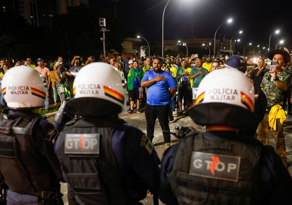 Police officers stand guard  during a protest in Brasilia, on December 12.