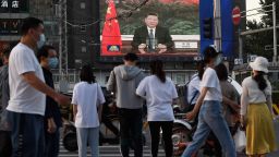 A news program shows Chinese President Xi Jinping speaking via video link to the World Health Assembly, on a giant screen beside a street in Beijing on May 18, 2020.