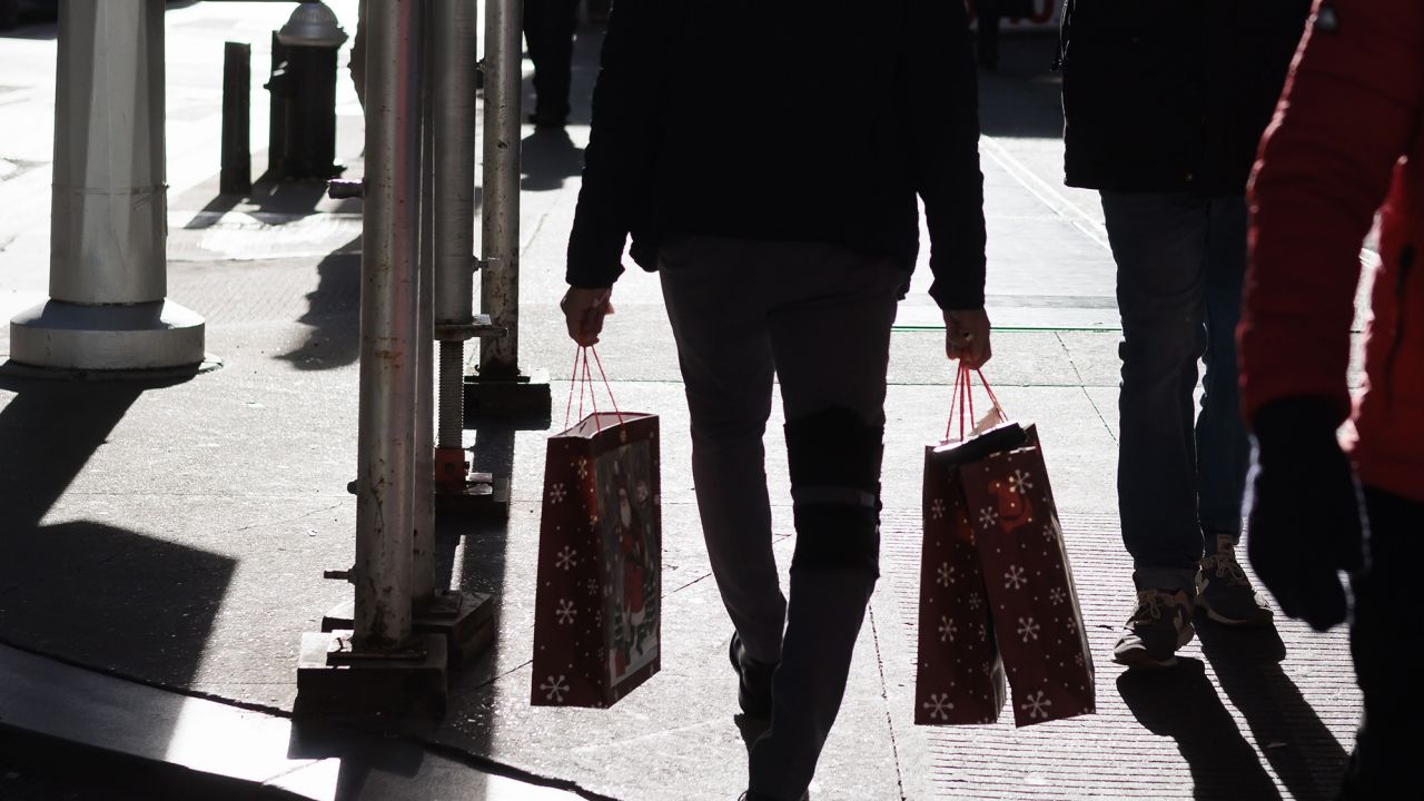 A person carrying shopping bags in New York, New York, on December 14. Consumer sentiment improved in December as inflation eased, but Americans remain downbeat about the overall economy, new data out of the University of Michigan showed.