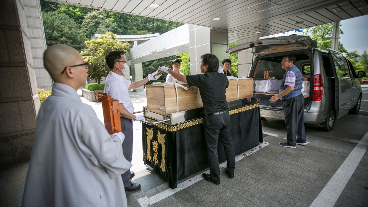 Staff at a non-profit organization, which holds funerals for those who died "lonely deaths," move a coffin at a crematorium in Goyang, South Korea, on June 16, 2016.