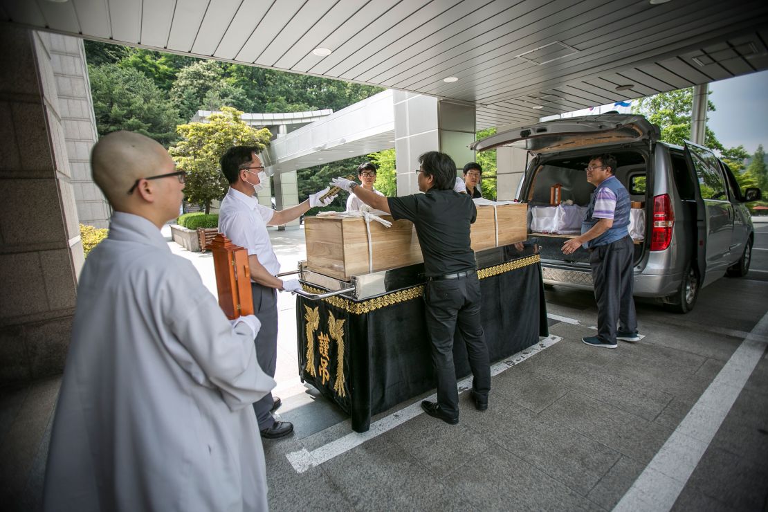 Staff at a non-profit organization, which holds funerals for those who died "lonely deaths," move a coffin at a crematorium in Goyang, South Korea, on June 16, 2016.