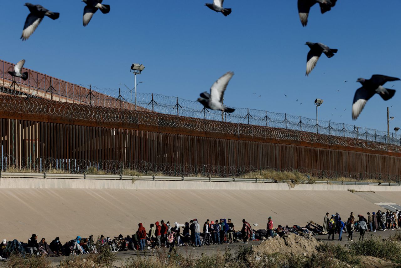 Migrants line up along the edge of the Rio Grande after <a href="https://www.cnn.com/interactive/2022/12/us/el-paso-crossings-migrant-stories-reaj-cnnphotos/" target="_blank">crossing into the United States</a> from Ciudad Juárez, Mexico, on Thursday, December 15.