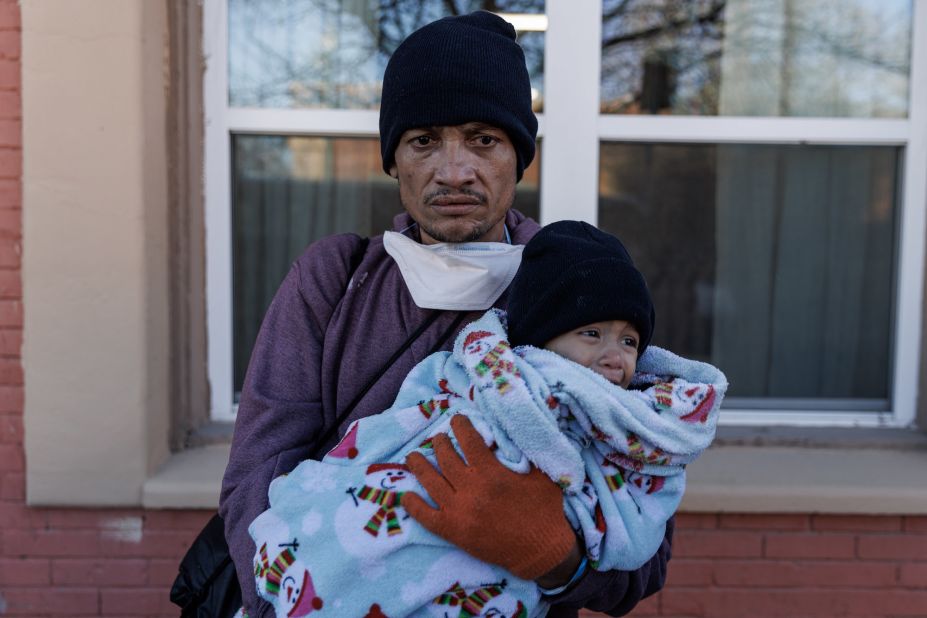 Carlos Pavon Flores, with 1-year-old daughter Esther, stands outside a shelter that turned them away for not having bus tickets in downtown El Paso on December 14.