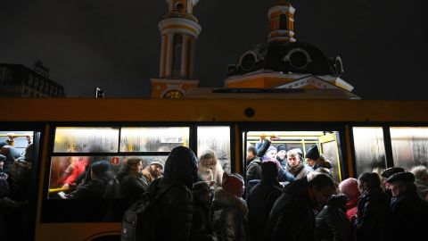 People get on a crowded bus at a public transport stop in Kyiv during an electricity blackout.