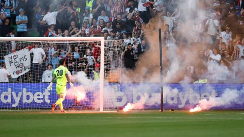 Paul Izzo removes a flare from the pitch after a Melbourne City goal during the game between Melbourne City and Melbourne Victory.  