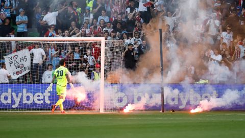 Paul Izzo removes a flare from the pitch after a Melbourne City goal during the game between Melbourne City and Melbourne Victory.
