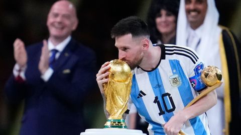 Lionel Messi kisses the World Cup trophy after receiving the Golden Ball award for the best player of the tournament.