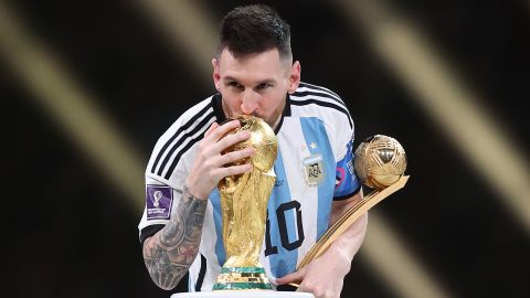 Lionel Messi kisses the FIFA World Cup trophy.