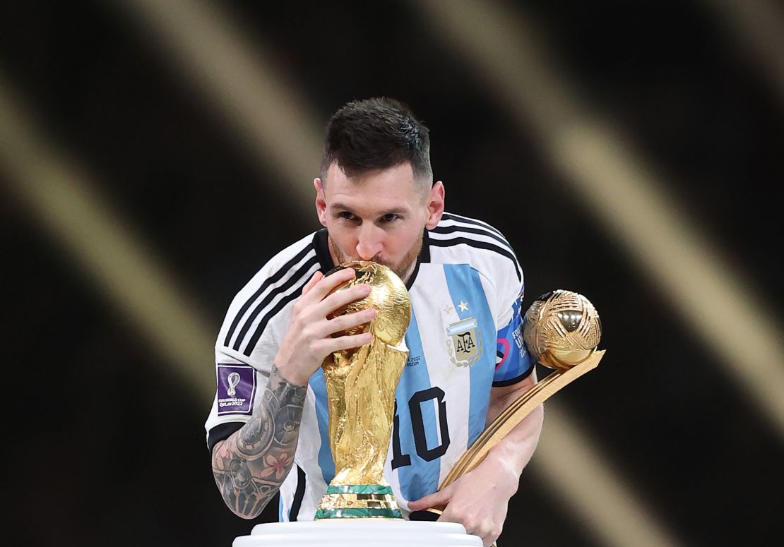 Lionel Messi kisses the FIFA World Cup trophy.