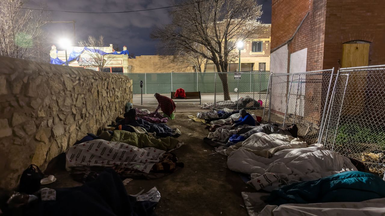 Migrants sleep in the cold outside a bus station on December 18, 2022 in El Paso, Texas.