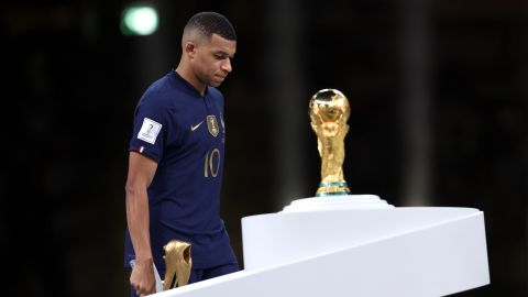 Kylian Mbappe walks past the trophy after scoring three goals in the final. 