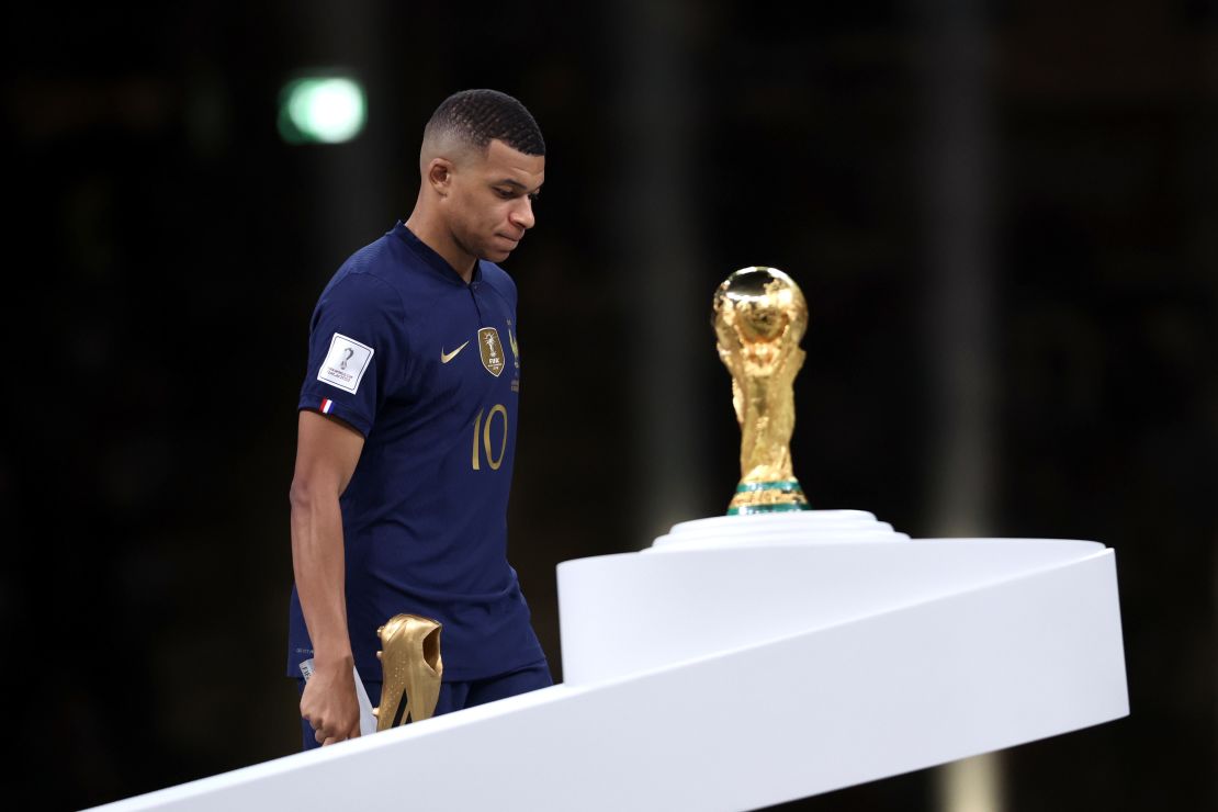 Kylian Mbappe walks past the trophy after scoring three goals in the final. 