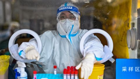 A health worker waits for people to take swab samples to test for Covid-19 in Shanghai on December 19, 2022.