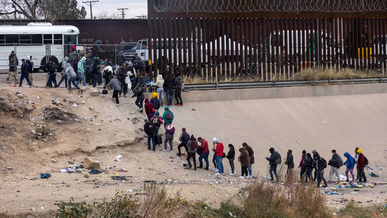 Immigrants seeking asylum turn themselves in to US Border Patrol agents after wading across the Rio Grande to El Paso, Texas, on December 18, 2022, from Ciudad Juarez, Mexico. 