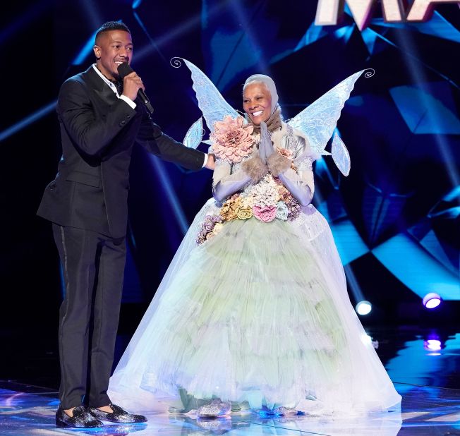 Host Nick Cannon and Warwick appear on stage after Warwick was unmasked during an episode of "The Masked Singer" in 2020.