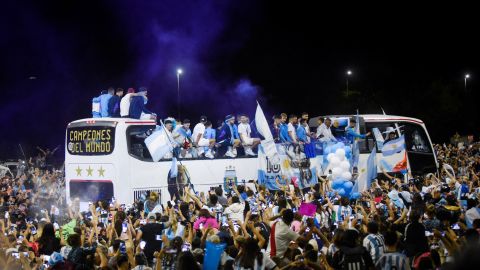 The Argentina football team on a bus in Buenos Aires on December 20, surrounded by cheering fans.