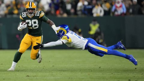 Green Bay Packers running back AJ Dillon avoids a tackle by Jalen Ramsey of the Los Angeles Rams.