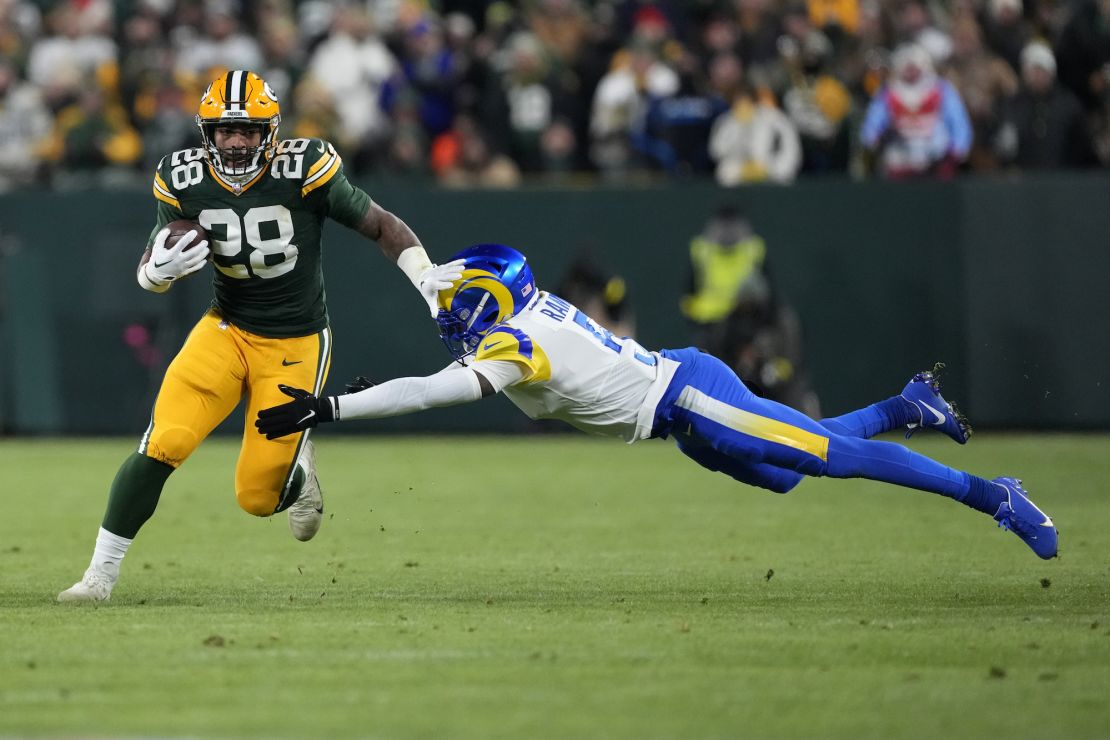 Green Bay Packers running back AJ Dillon avoids a tackle by Jalen Ramsey of the Los Angeles Rams.