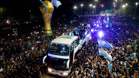 Argentina players celebrate on a bus with supporters after winning the World Cup.