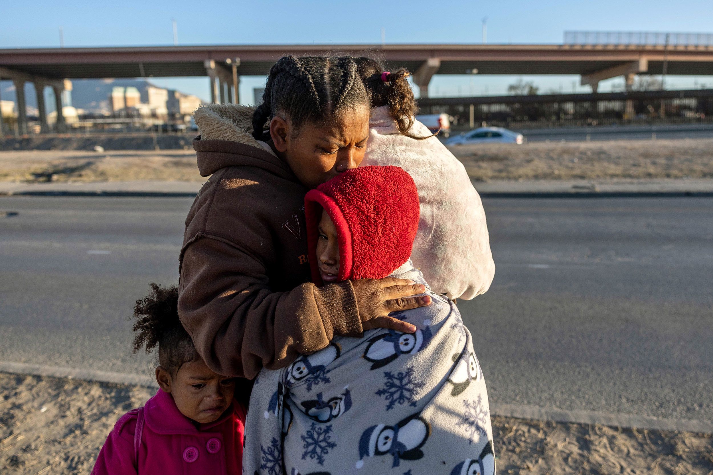 Venezuelan immigrant Yaneisi Martinez weeps while embracing her three children after Texas National Guard troops and state police blocked a popular border crossing area on December 20 in Ciudad Juárez, Mexico.