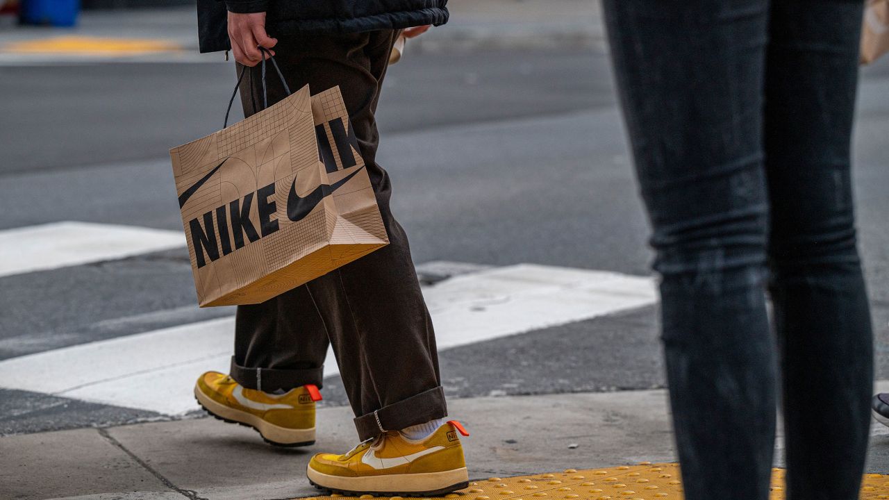 A pedestrian carries a Nike shopping bag in San Francisco, California, US, on Friday, Dec. 9, 2022.