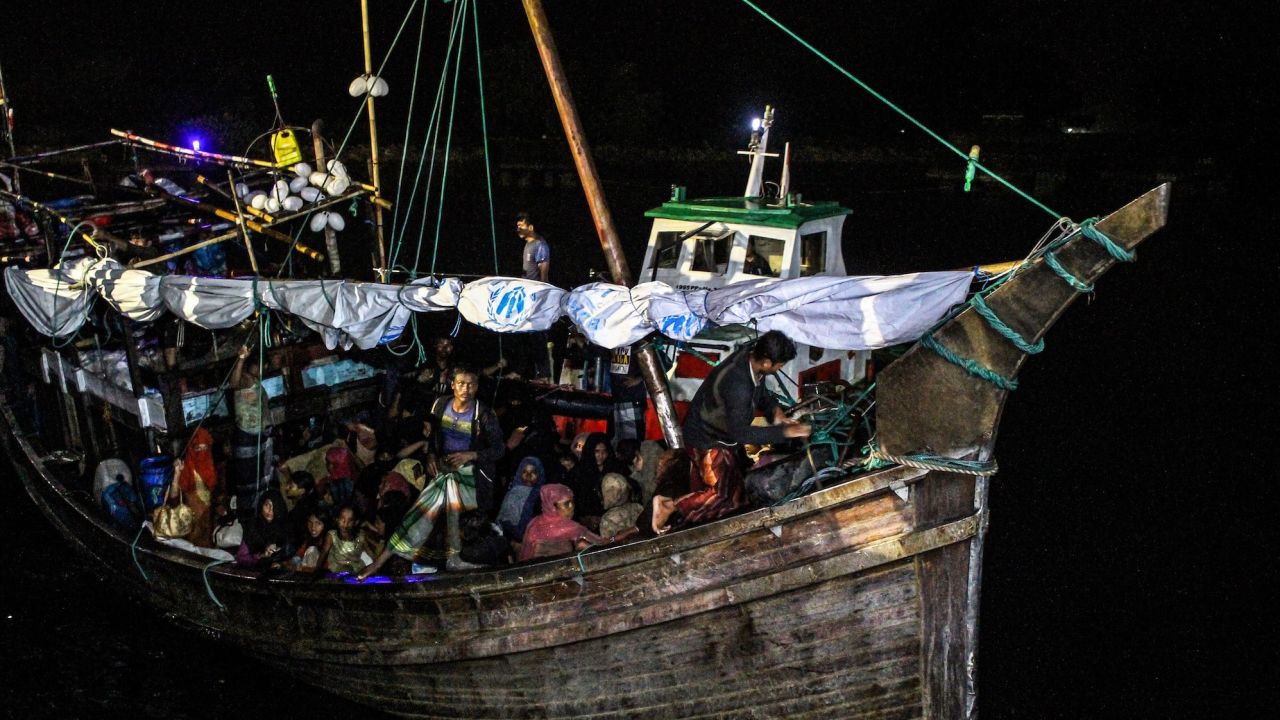 In this file photo, Rohingya refugees sit on a wooden boat as Indonesian officials conduct an evacuation at the Krueng Geukueh port in Lhokseumawe, Aceh, Indonesia, Dec. 31, 2021. 